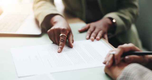 Close-up of business people's hands pointing to documents